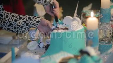 新娘和新郎的手切一片婚礼蛋糕。 切结婚蛋糕。 人们切蛋糕，把蛋糕放在盘子里